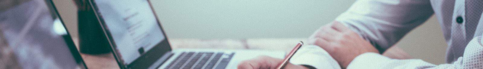 Deux personnes collaborent avec ordinateurs portables et documents sur un bureau.